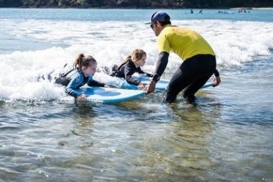 a young girl riding a wave on a surfboard in the water