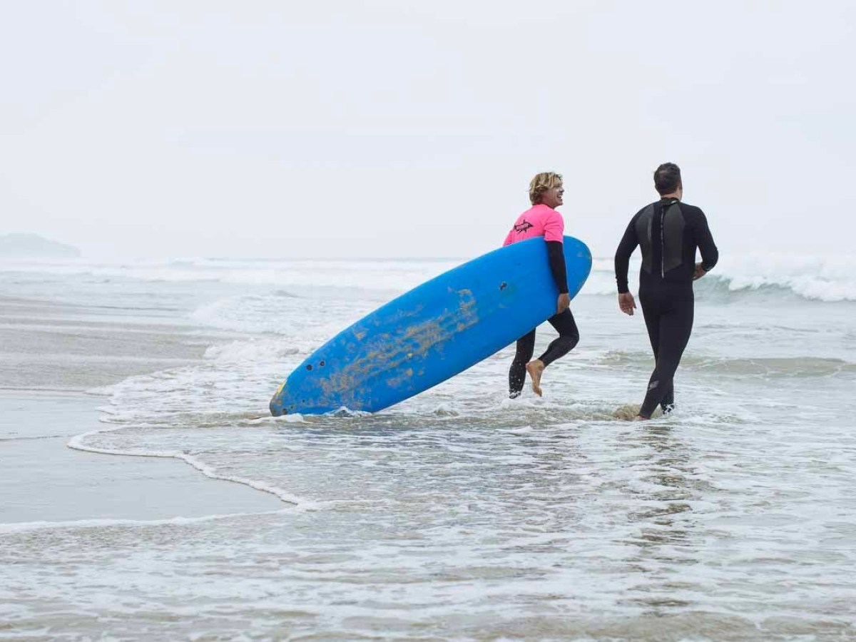 a man in a wet suit carrying a surf board