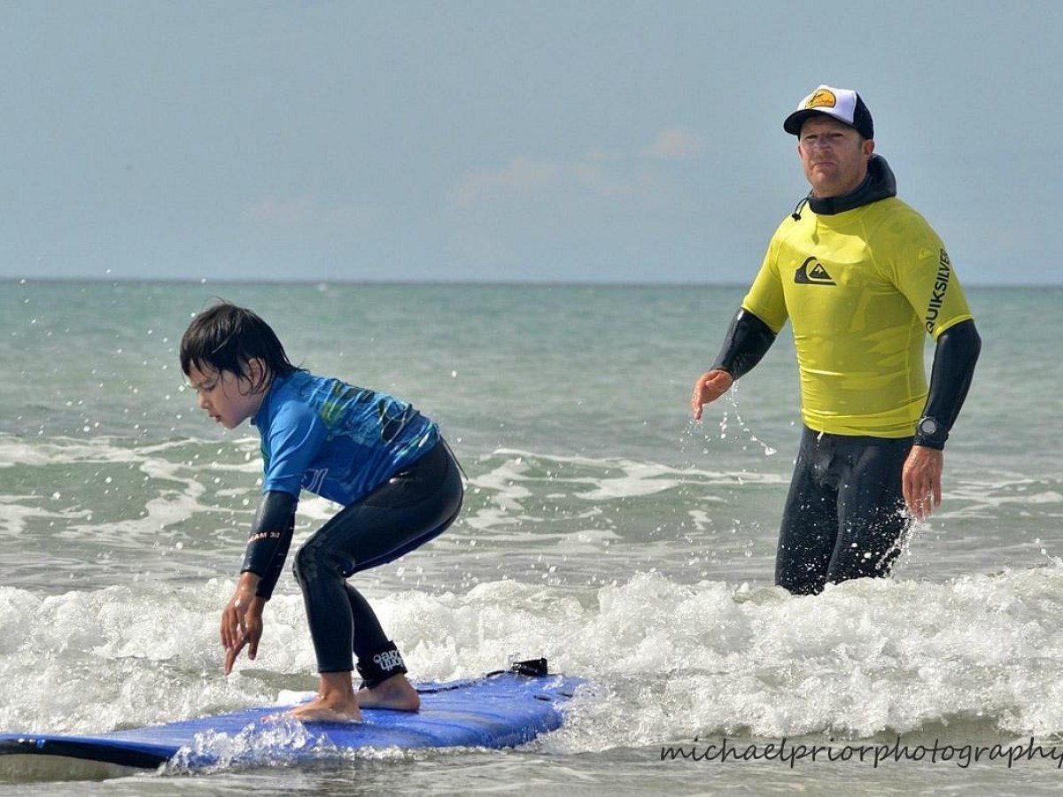 a young man riding a wave on a surfboard in the ocean