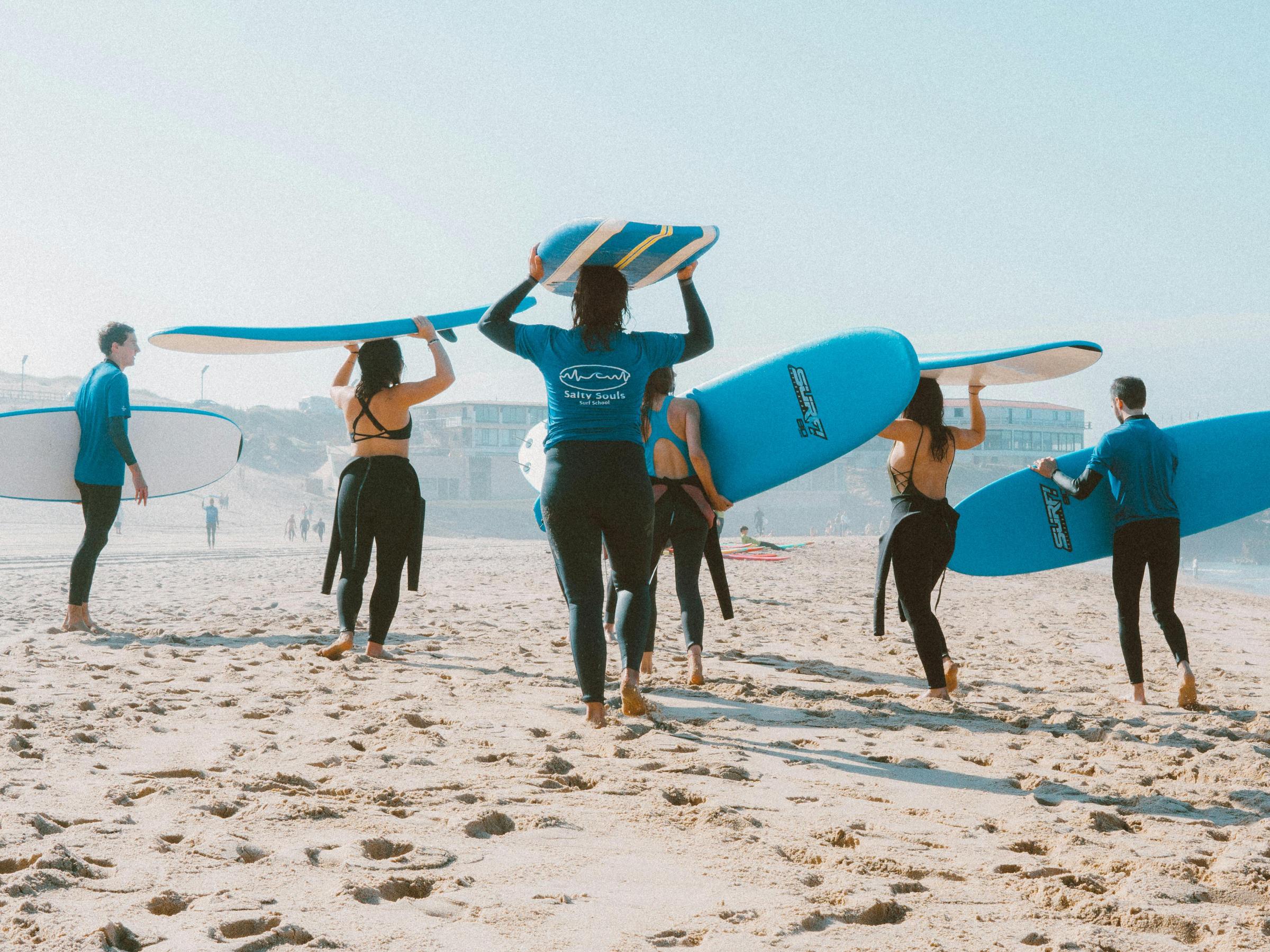 a group of people walking on a sandy beach