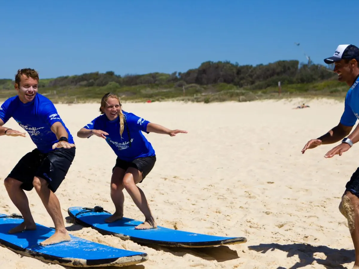 a group of people standing on top of a sandy beach