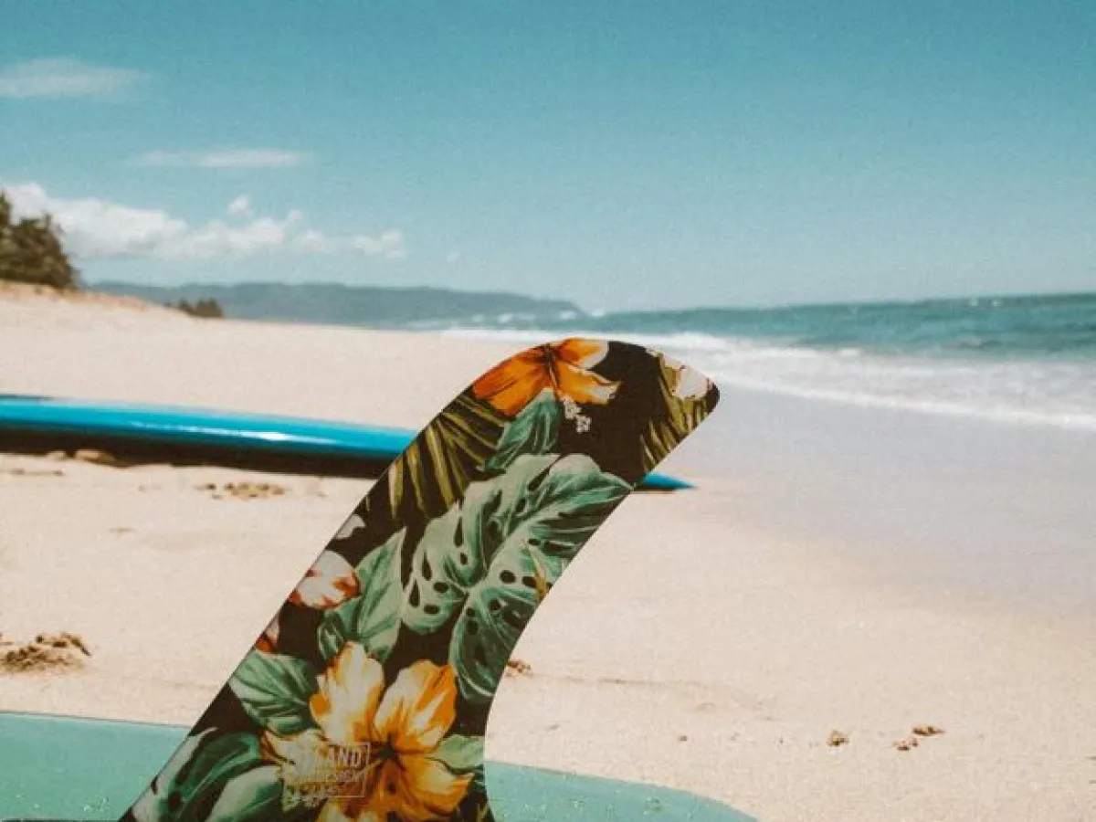 a beach with a surf board on a body of water